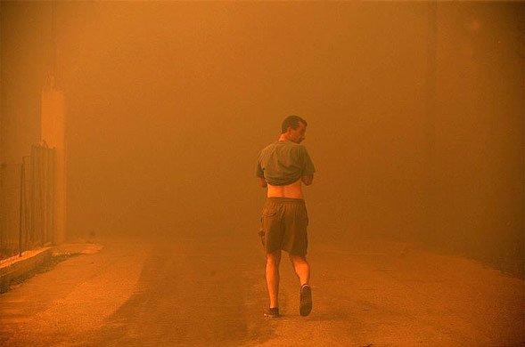 A man leaves the burning village near ancient Olympia