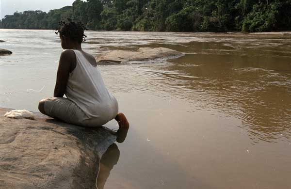A woman washes on the bank of the Ulindi river