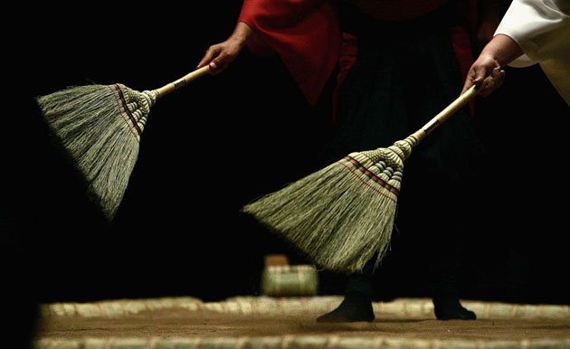 Loose clay is swept off the ring