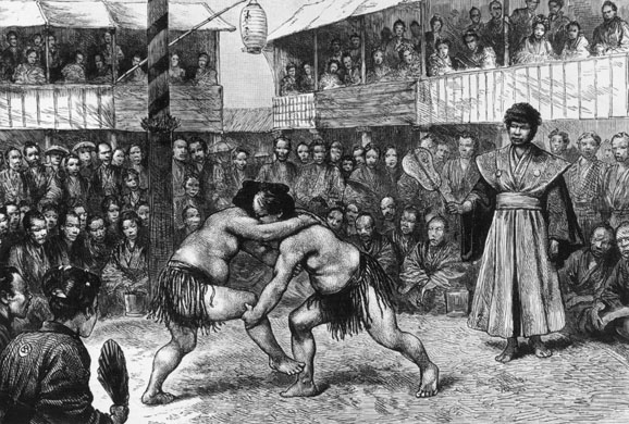 A crowd watches sumo wrestling match