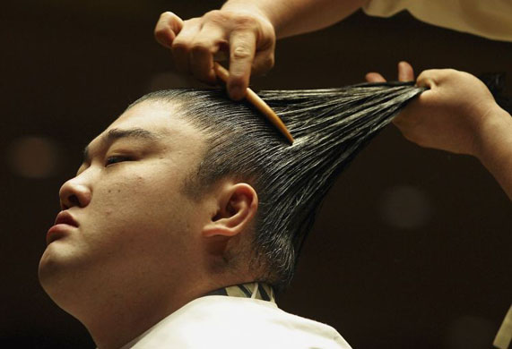 A sumo wrestler gets his topknot done