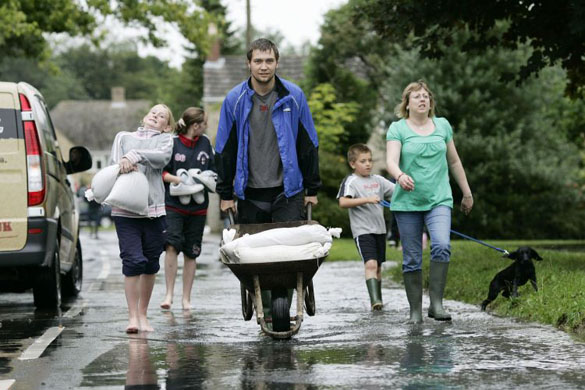 Residents of Standlake load sandbags into a wheel barro