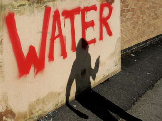 The shadow of a woman collecting bottled water