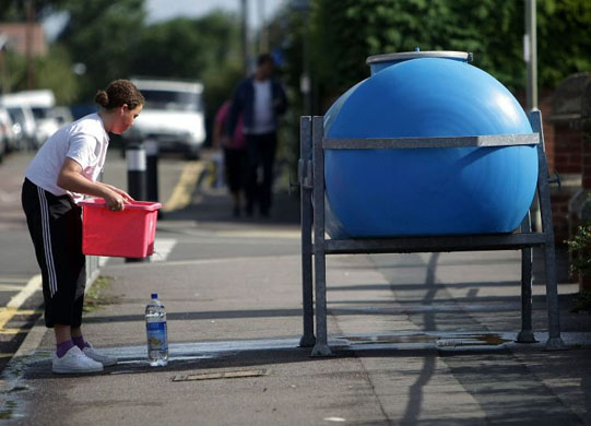 A resident collects emergency water from a bowser in Tewkesbury