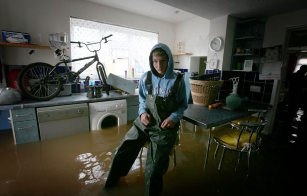 Scott Aitken sits in the kitchen of his flooded home