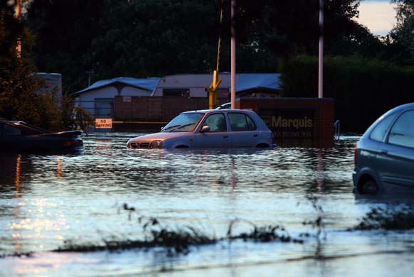 Abandoned cars sit in a flooded carpark 