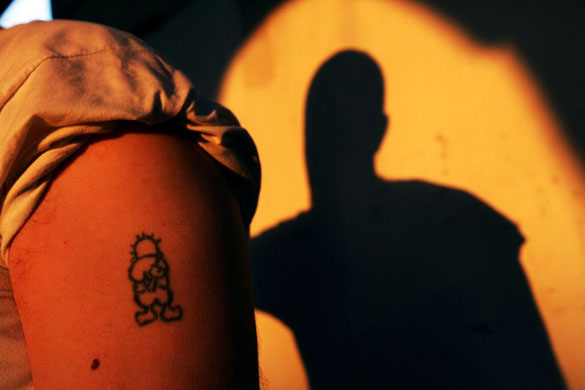 A tattoo on the shoulder of a Palestinian fighter depicts a famous revolutionary cartoon figure called Handhalah