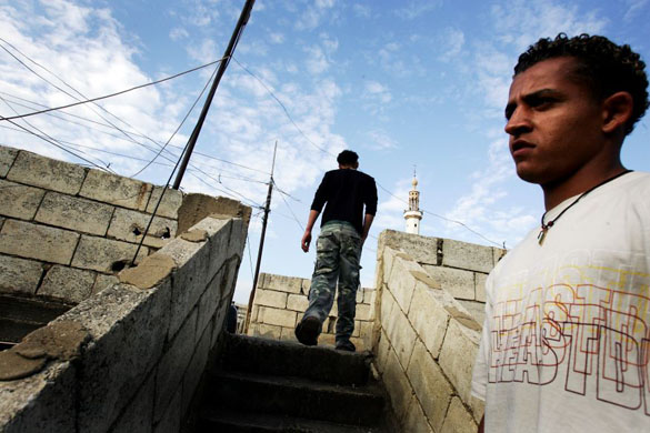 Saleh, a secular young man, stands at the stairs of his house