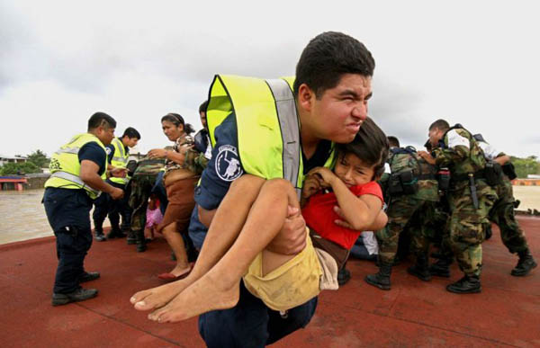 Members of the navy help residents of the flooded city board a helicopter