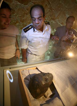 A military officer inspects the mummy