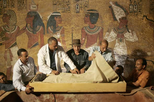 Workers unwrap the mummy