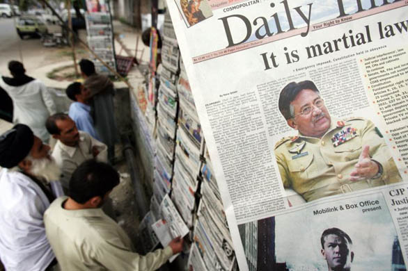 People read newspapers in Islamabad a day after the president declared a state of emergency