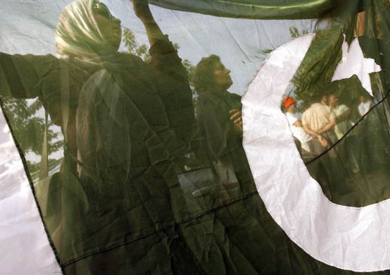 Civil rights activists hold a Pakistani flag at an anti-government protest in Islamabad