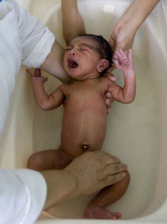 A baby is bathed in a flood shelter