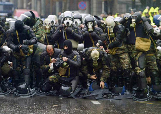 Security forces put on their gas-masks as they prepare to confront anti-government protesters