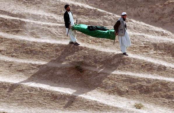 Men carry a body of a suicide attack victim for burial in Baghlan