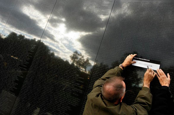 Mark Rumley of Medford, Massachusetts, makes a rubbing of a name from the Vietnam Veterans memorial