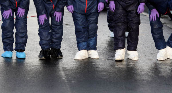 Forensic officers examine the scene of a shooting after a police officer was seriously
