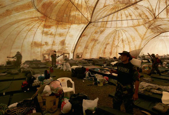 Soldiers fumigate a shelter for flood victims that has been temporarily emptied