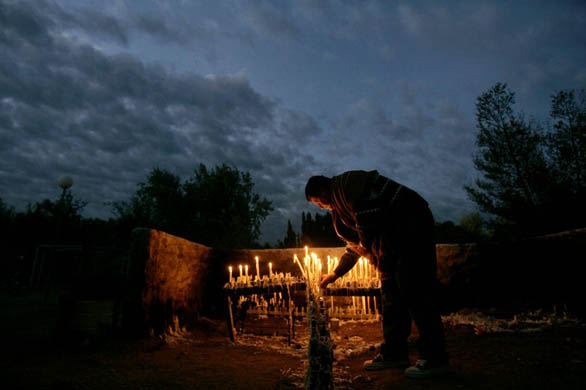 A man lights candles before the beatification ceremony of Argentine Indian Ceferino Namuncura