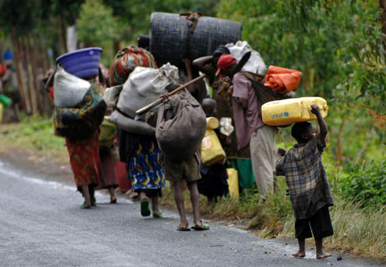 People carry their belongings down a road