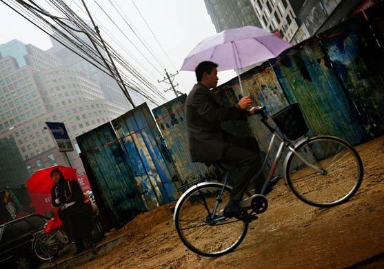 A man rides his bicycle in the rain