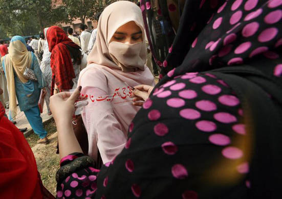 tudents attach protest stickers against the emergency declared by president General Pervez Musharraf minutes before cricket hero and politician Imran Khan is detained by police