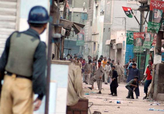 A riot policeman looks on