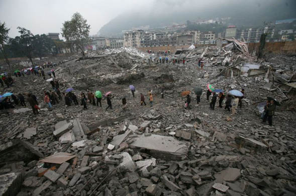 Residents walk among ruins after 13 buildings were demolished