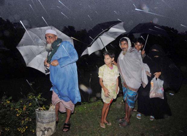 Residents look on as the rain pelts down