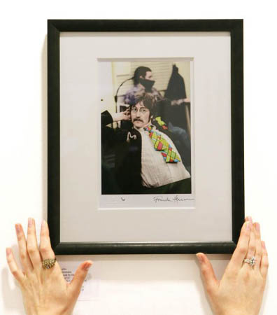 An employee of the Leinster Gallery hangs a photograph of John Lennon