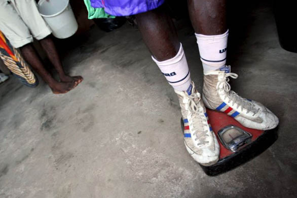 A boxer from Ghana checks his weight after an afternoon training session at the Akotoku Academy boxing club