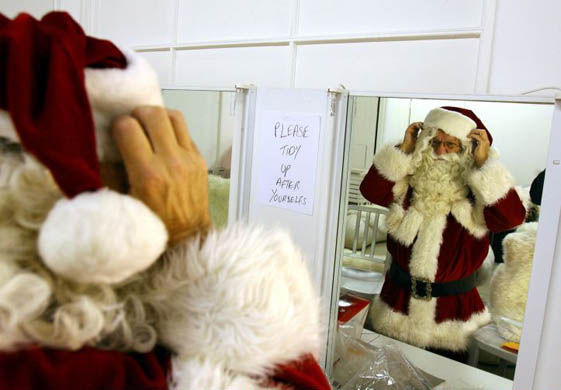 Professional Santa Claus Reuben Reisler tries on his costume in a storeroom at Selfrides