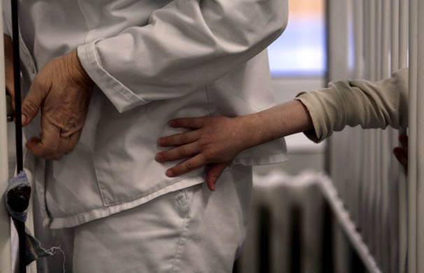 A patient tries to reach a nurse's uniform at a centre for the disabled