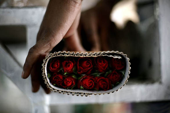 A woman prepares a bunch of roses at a flower farm
