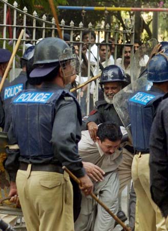 Pakistani policemen beat a journalist during a demonstration 