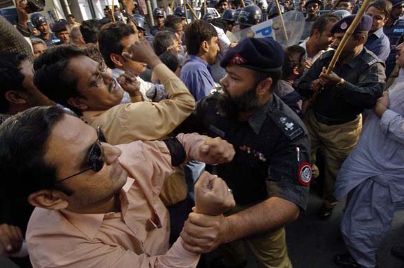 Pakistani policemen arrest protestors