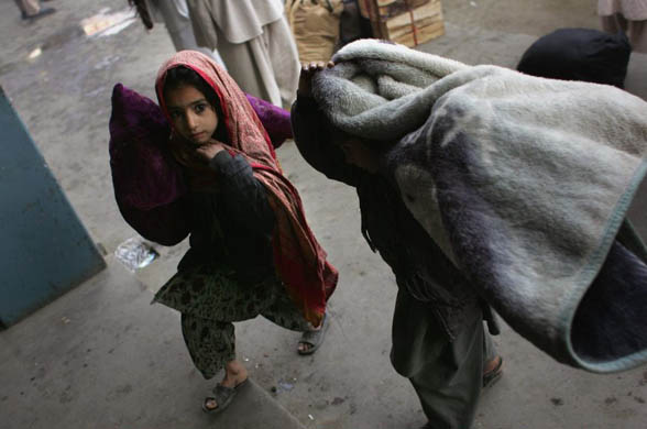 Displaced children carry blankets after fleeing their home