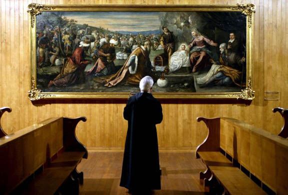 A priest looks at the Tintoretto oil painting 'The Worship of the Magi'