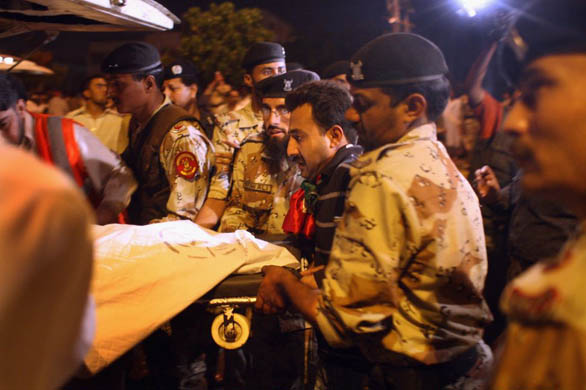 Army and rescue personell load a body into an ambulance