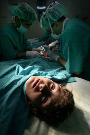 Doctors conduct surgery on the hand of Omar Hamada