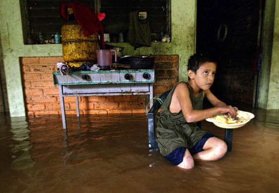 A child eats in a flooded community