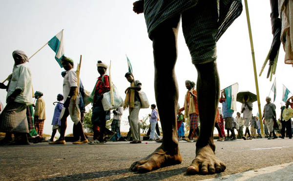 A landless farmer walks barefoot