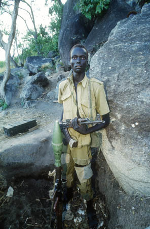 A Sudanese People's Liberation Army soldier stands with his weapons