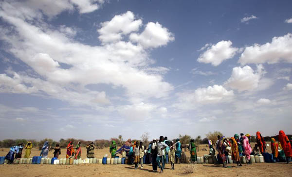 Refugees wait for water at a refugee camp