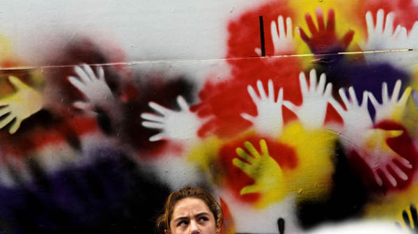 A woman passes anti-war graffiti