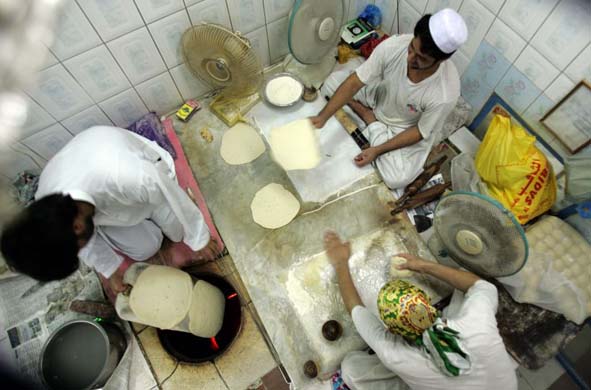 Afghani bakers living in Dubai make bread in a traditional oven