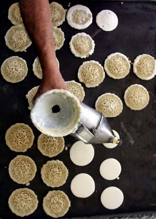  A Palestinian baker makes small traditional pancakes