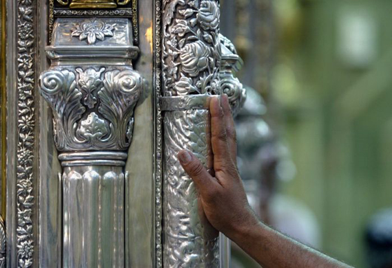 A hand touches the Imam Hadrat al-Abbas Shrine