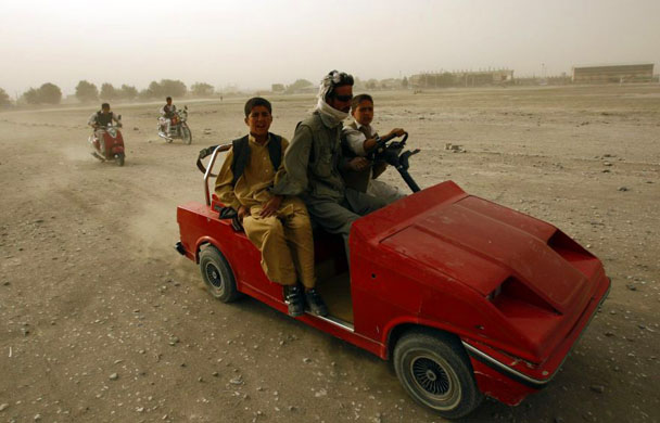 Locals ride in an electric car during a dust storm  ib Kabul 